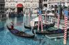 A gondolier wearing a protective mask travels on a gondola through the Grand Canal at the Venetian Resort.