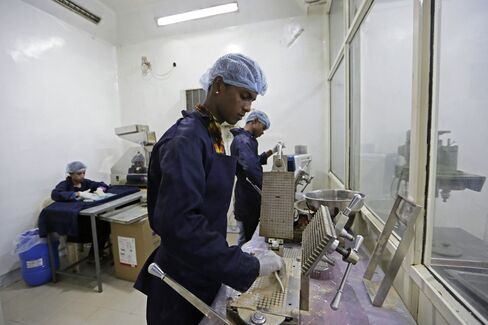 Workers process cow urine into capsules at Jains factory.