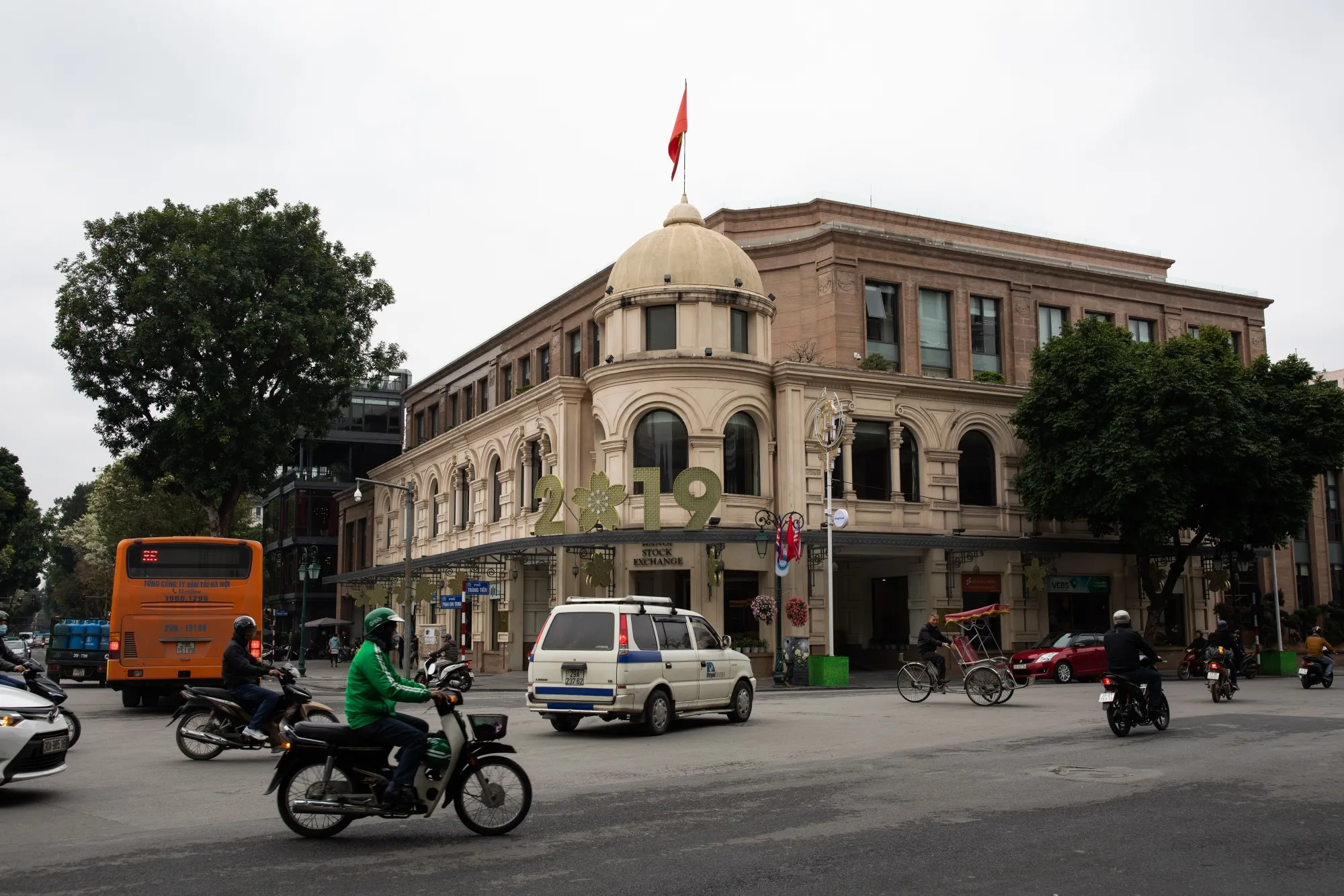 Vehicles drive past the Hanoi Stock Exchange (HNX) in Hanoi, Vietnam.