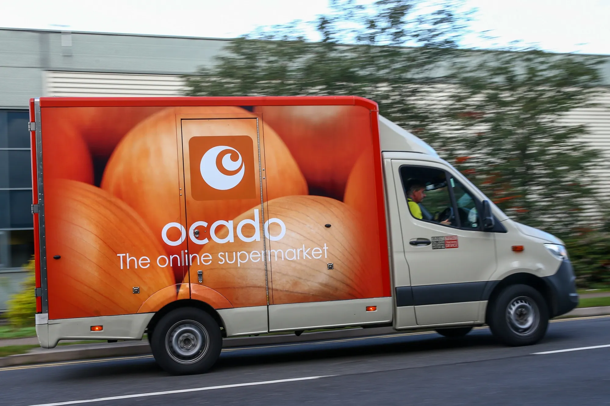 A grocery delivery truck operated by an Ocado departs from a fulfillment centre in Enfield, UK.