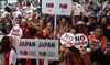 South Koreans participate in a rally to denounce Japan's new trade restrictions on South Korea in Seoul .