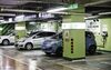 Electric automobiles sit connected to a charging station in Beijing,