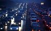 Traffic moves along a road at dusk in Beijing, China, on Tuesday, March 5, 2013. China maintained its economic-growth target at 7.5 percent for 2013 while setting a lower inflation goal of 3.5 percent, setting up a challenge for new leaders to keep prices in check without harming expansion.