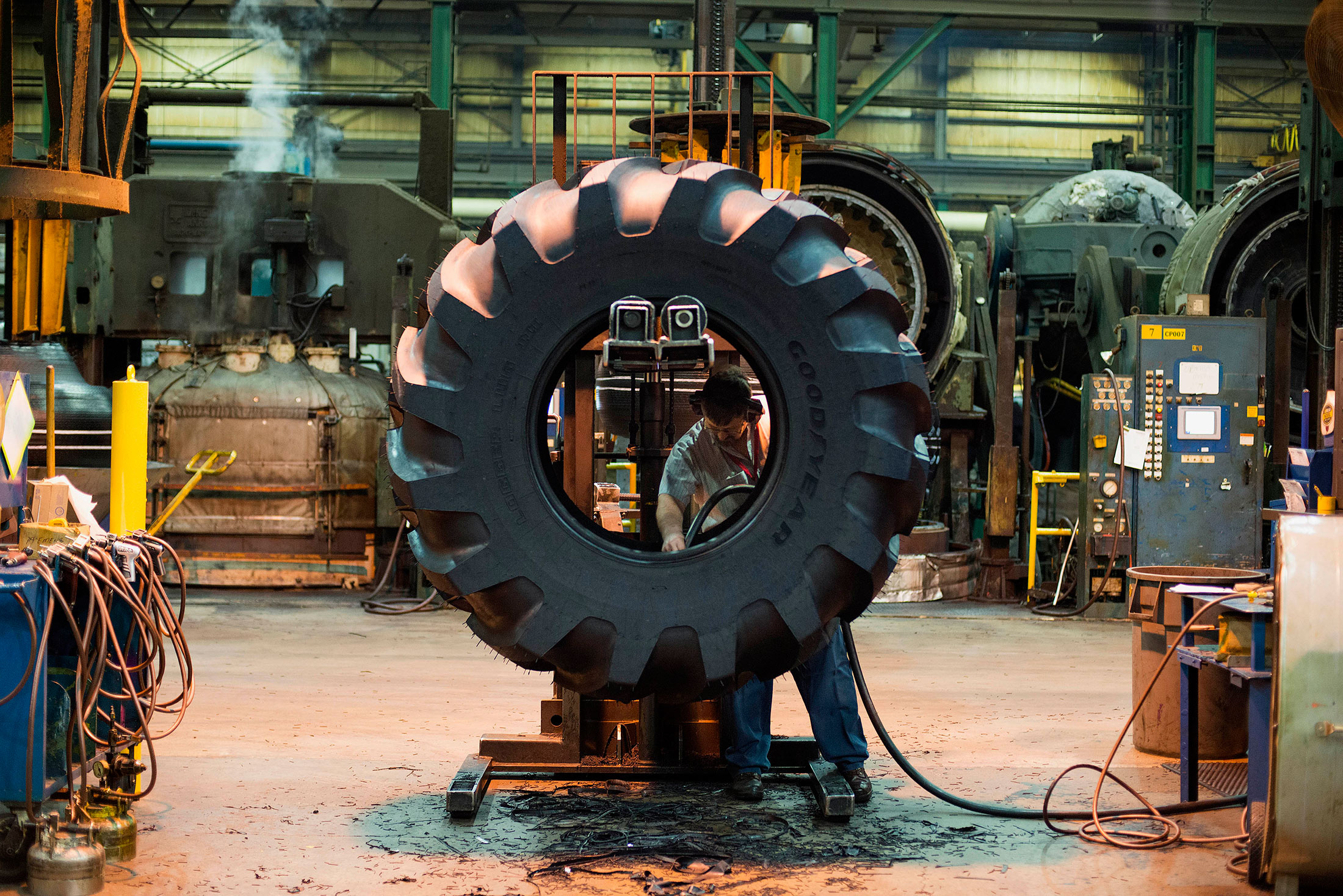 An employee works on the inside of a tire at a tire manufacturing facility in Bryan, Ohio, on March 13, 2015.
