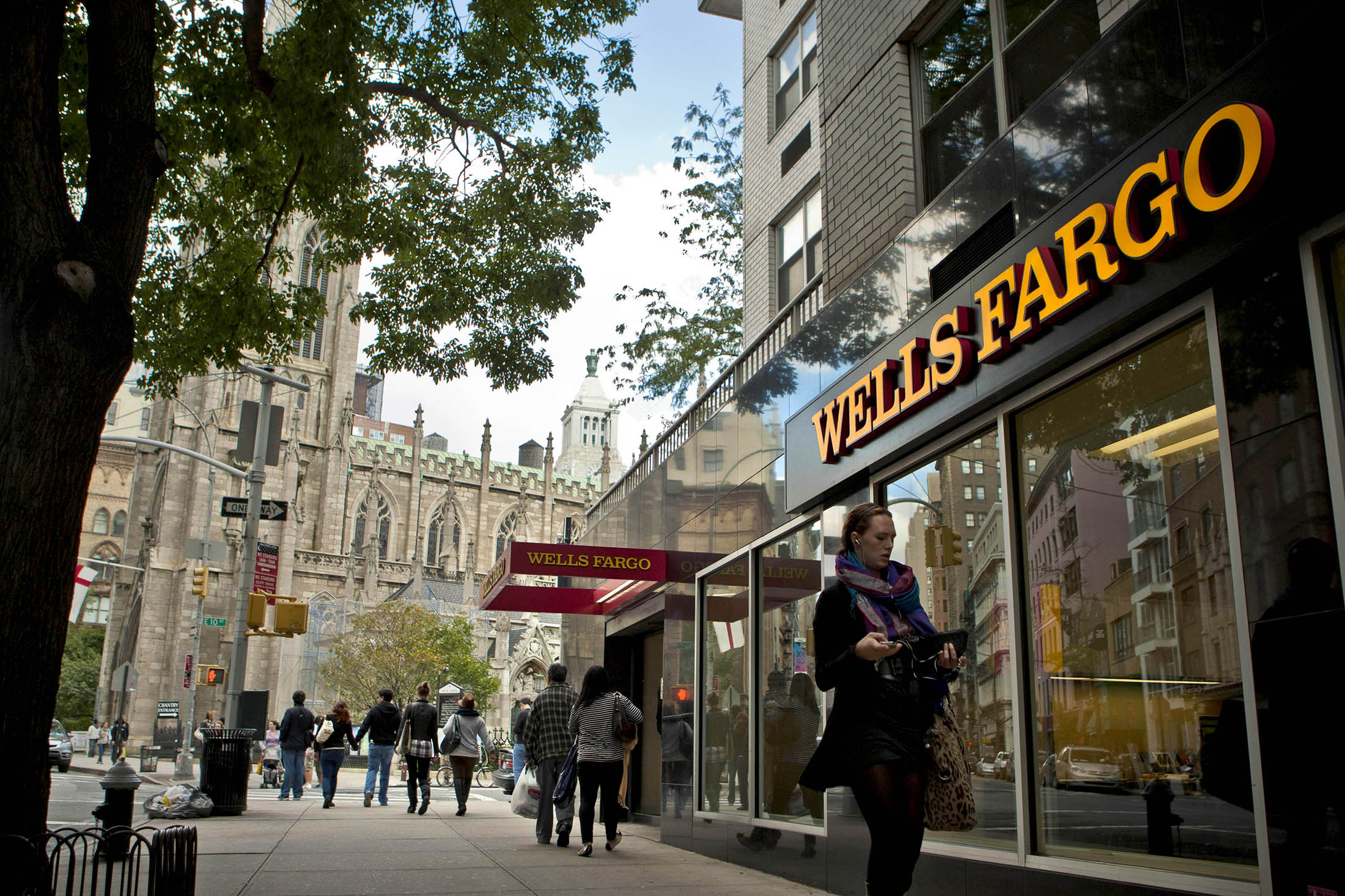 Pedestrians pass a Wells Fargo bank branch in New York.
