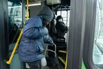 A bus driver in Ohio wears a protective mask as a passenger boards on March 17. Several transit agencies in the state are stopping fare collection.