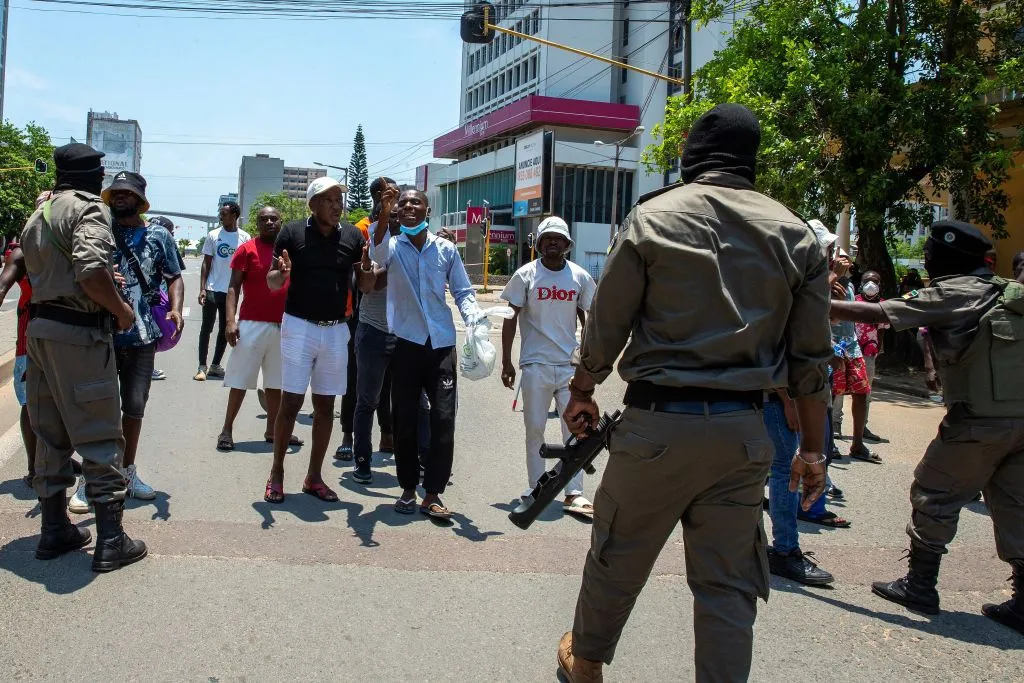 Mozambique police officers look on as protesters argue with them in Maputo on Jan.&nbsp;15.