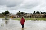 A man walks through a flooded field to his home in Mikocheni area of Dar es Salaam, Tanzania, on April 12