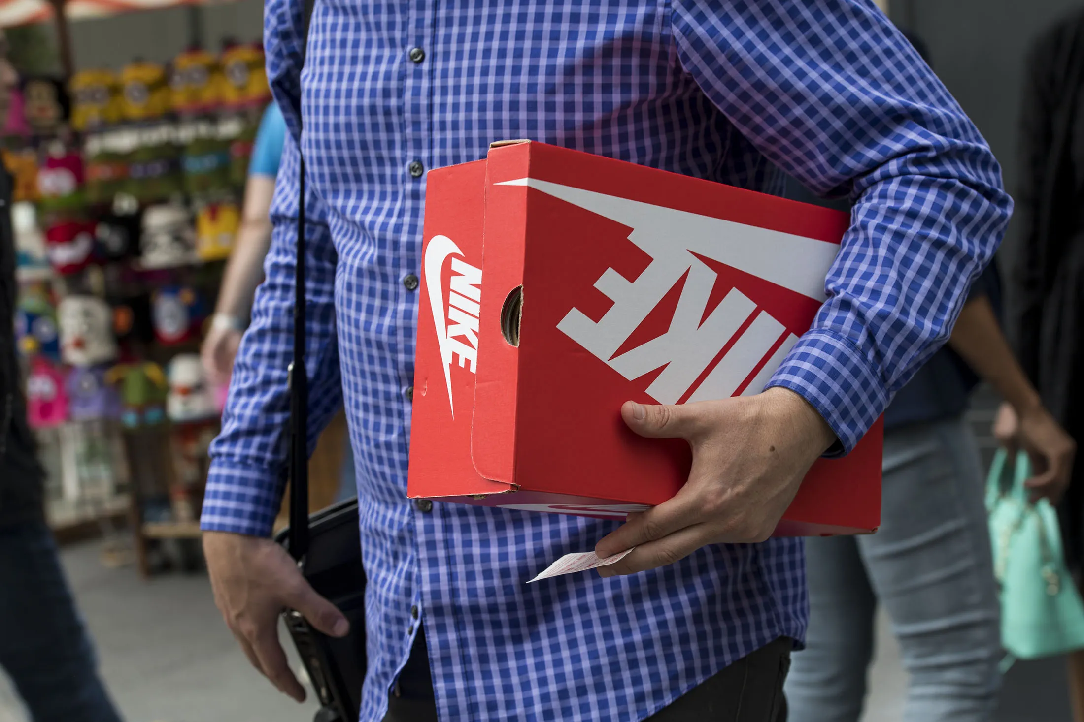 A shopper carries a Nike shoe box in San Francisco, California.
