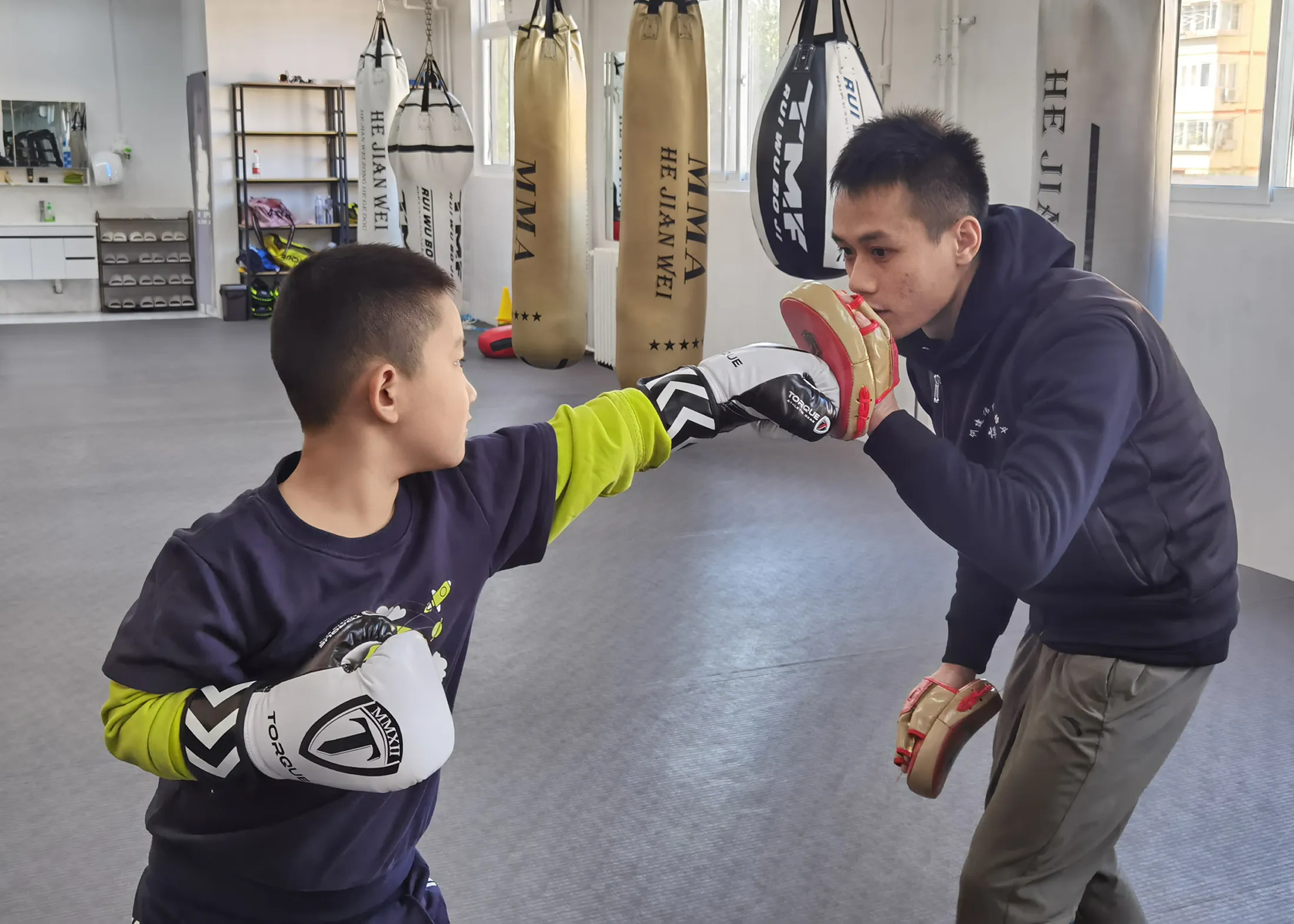 Guoguo, left, trains with a coach at a boxing club in east Beijing.