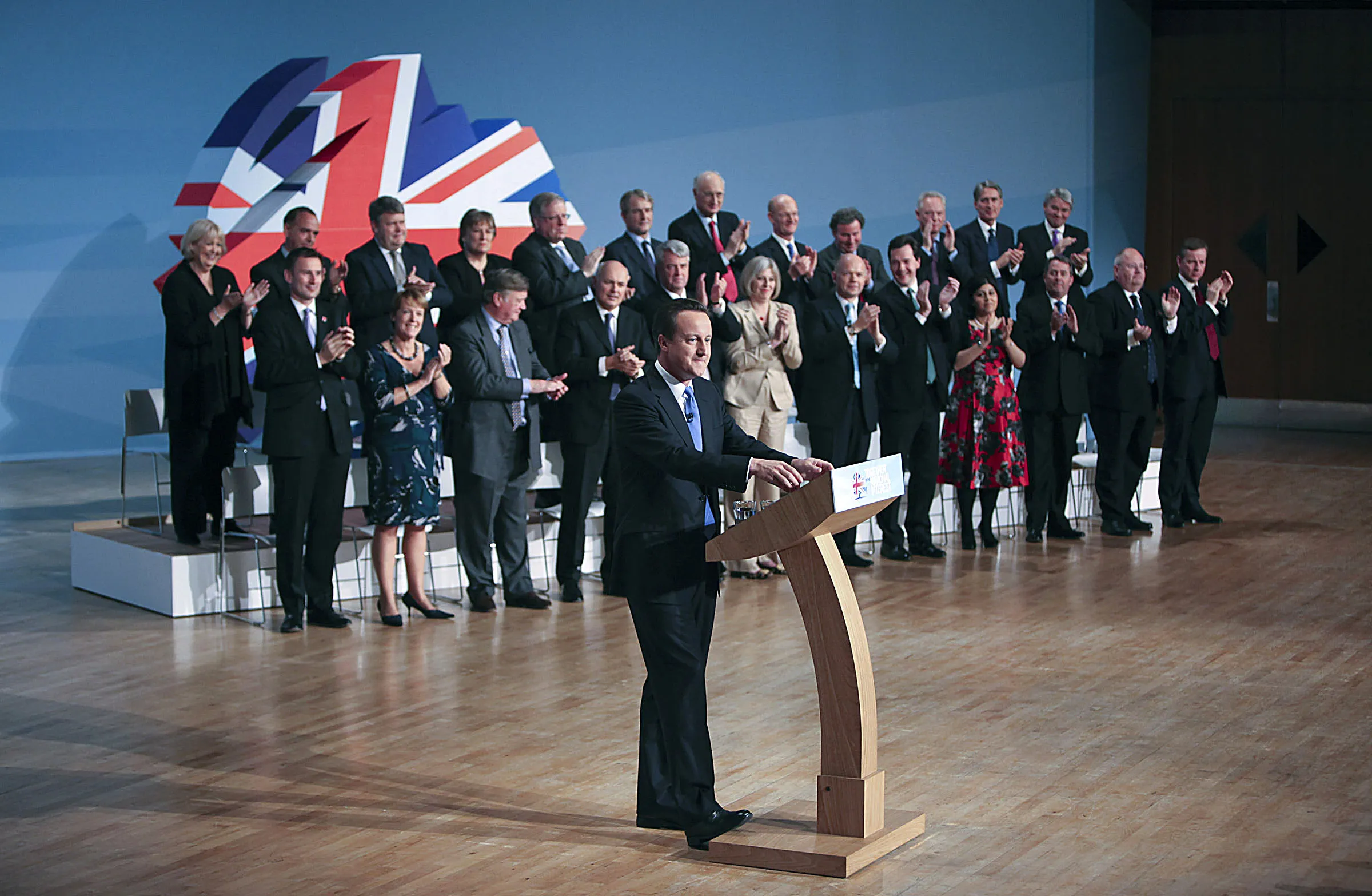 Prime Minister David Cameron, center at podium, speaks at the Conservative Party's annual conference in Birmingham, U.K., on Oct. 6, 2010.
