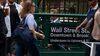Pedestrians pass the Wall Street subway station near the New York Stock Exchange.
