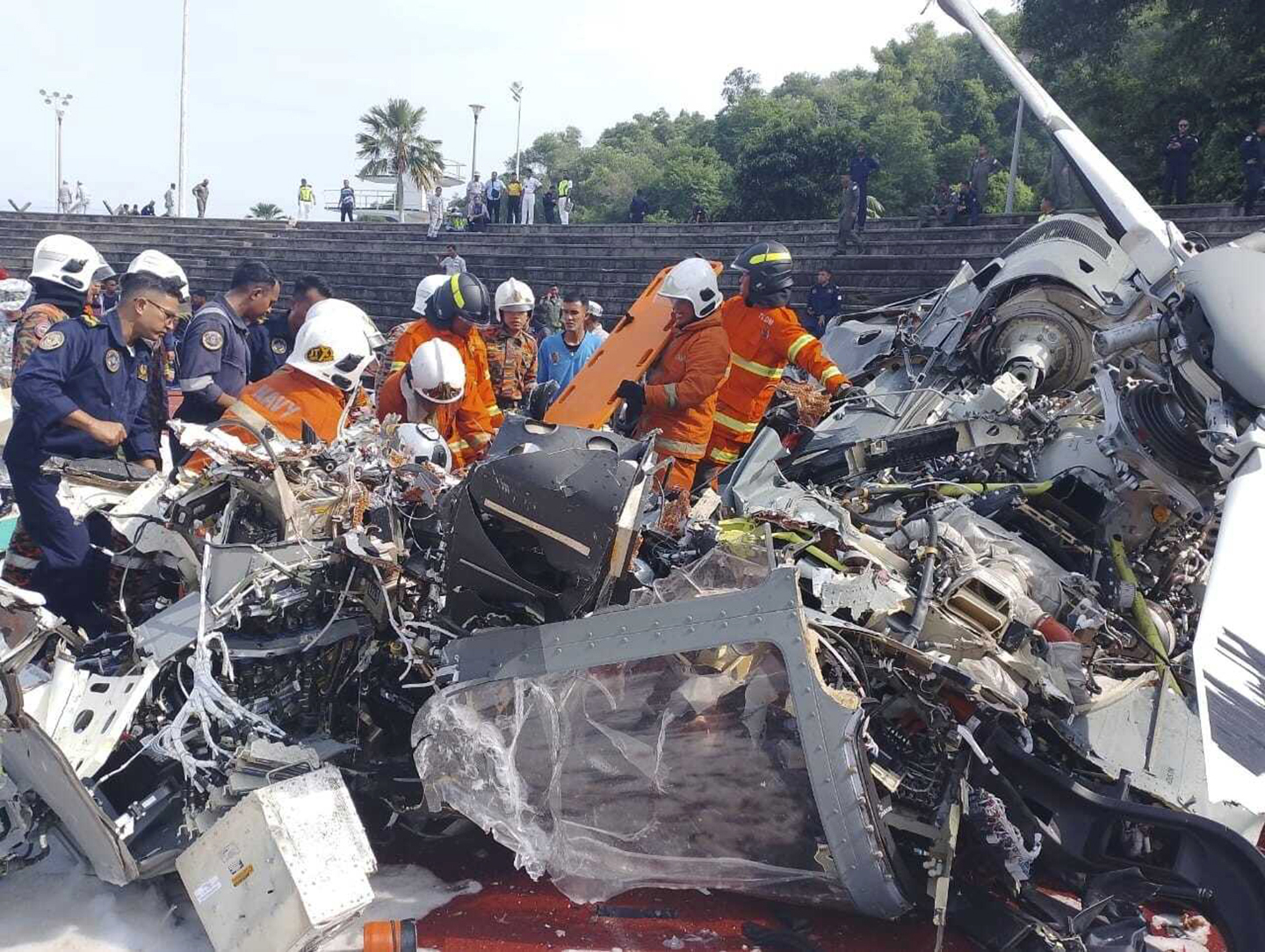 First responders inspect the crash site of two helicopters in Perak state on April 23.