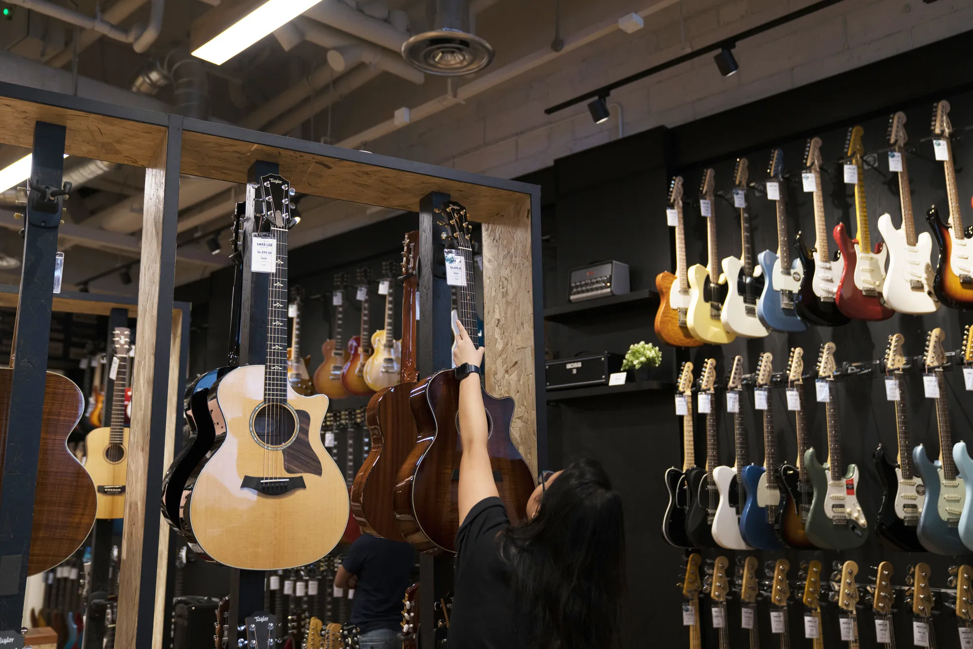 A customer puts back a guitar on display at the Swee Lee Holdings Pte Star Vista Lifestyle Store in Singapore, on Wednesday, Nov. 22, 2017.&nbsp;