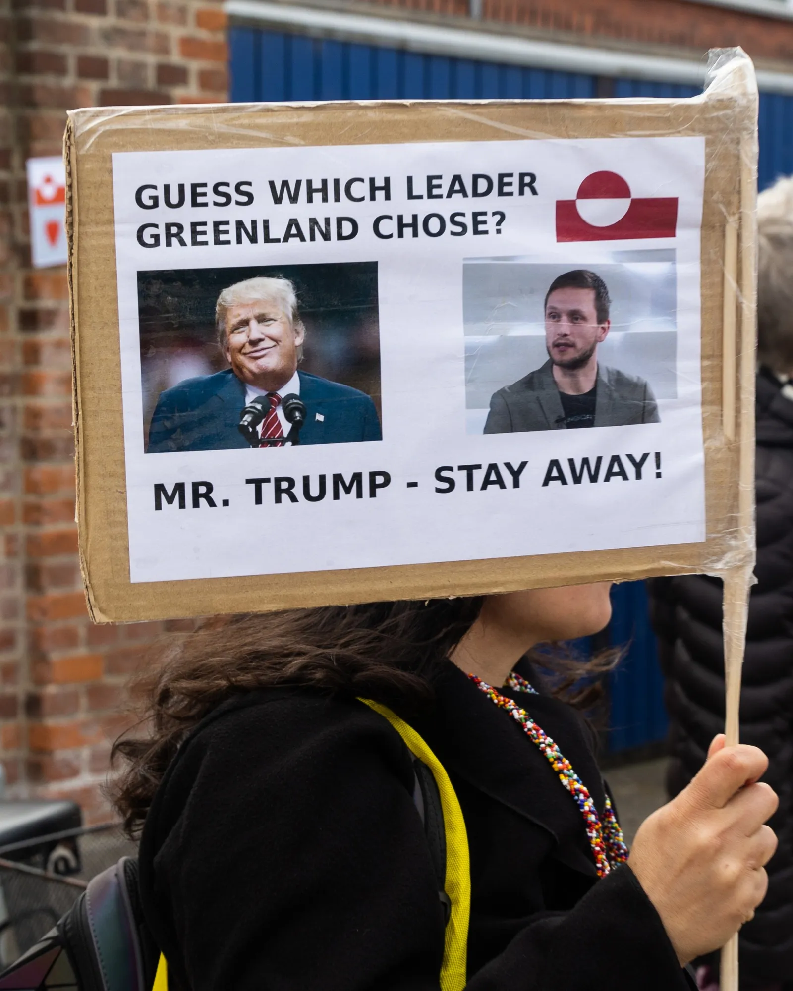 A protester holds a placard with a photo of United States