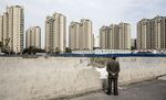 A man looks as residential buildings stand in the distance in the Jiading district of Shanghai on April 11.
