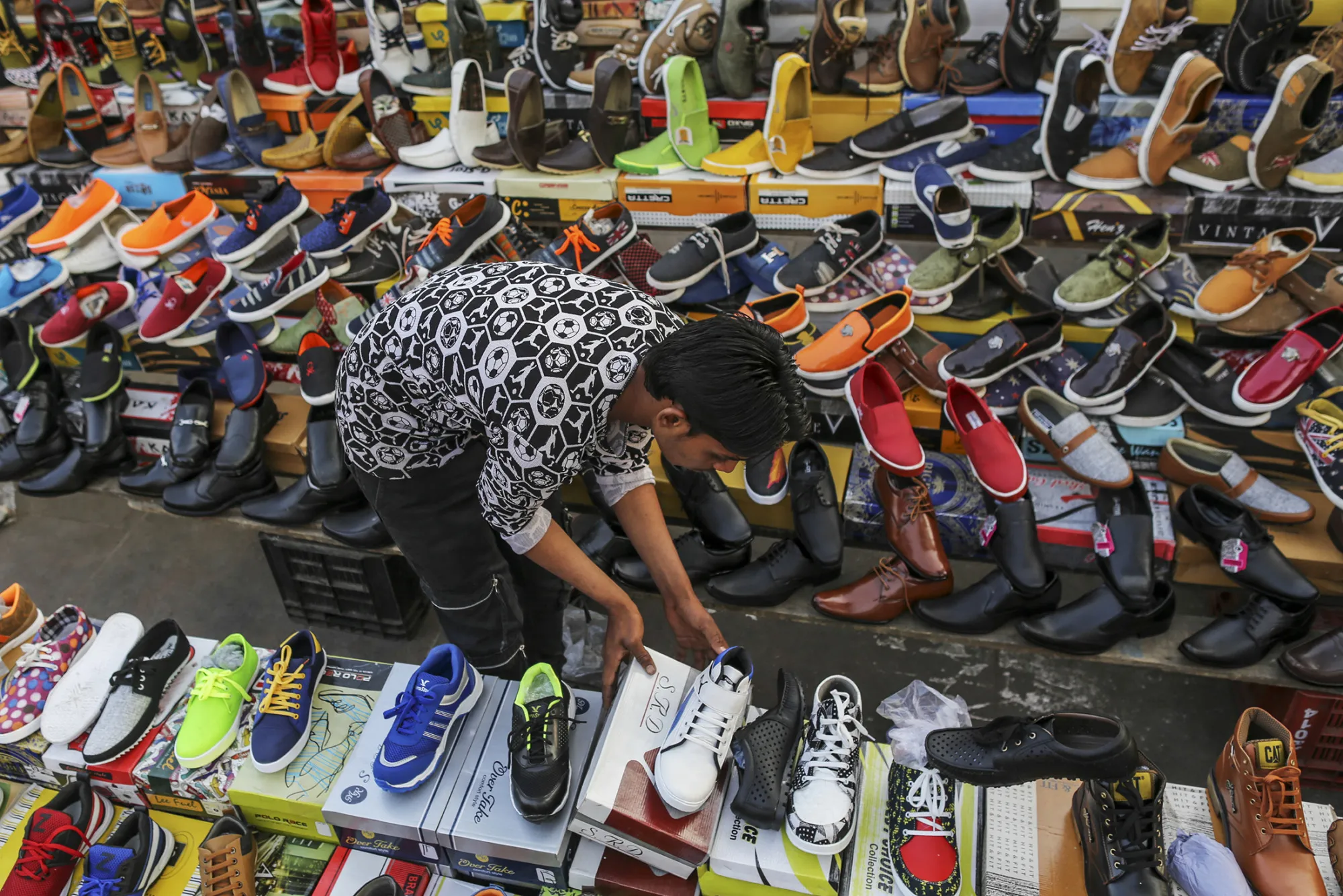 A vendor arranges shoe boxes at a market stall in Ahmedabad, Gujarat, India, on Jan. 11, 2017.
