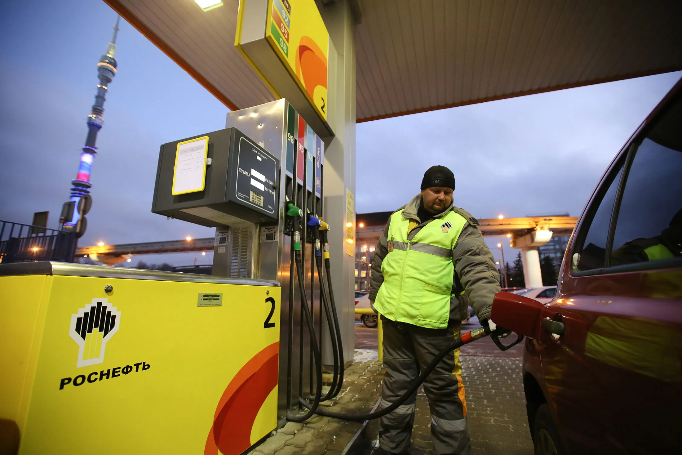 A station attendant refuels a vehicle at an OAO Rosneft gas station in Moscow, Russia, on Tuesday, Dec. 2, 2014. Russia plans to hold five oil-field tenders in easily accessible areas in the first quarter to help producers keep output stable as sanctions block development of remote provinces and crude prices plunge.
