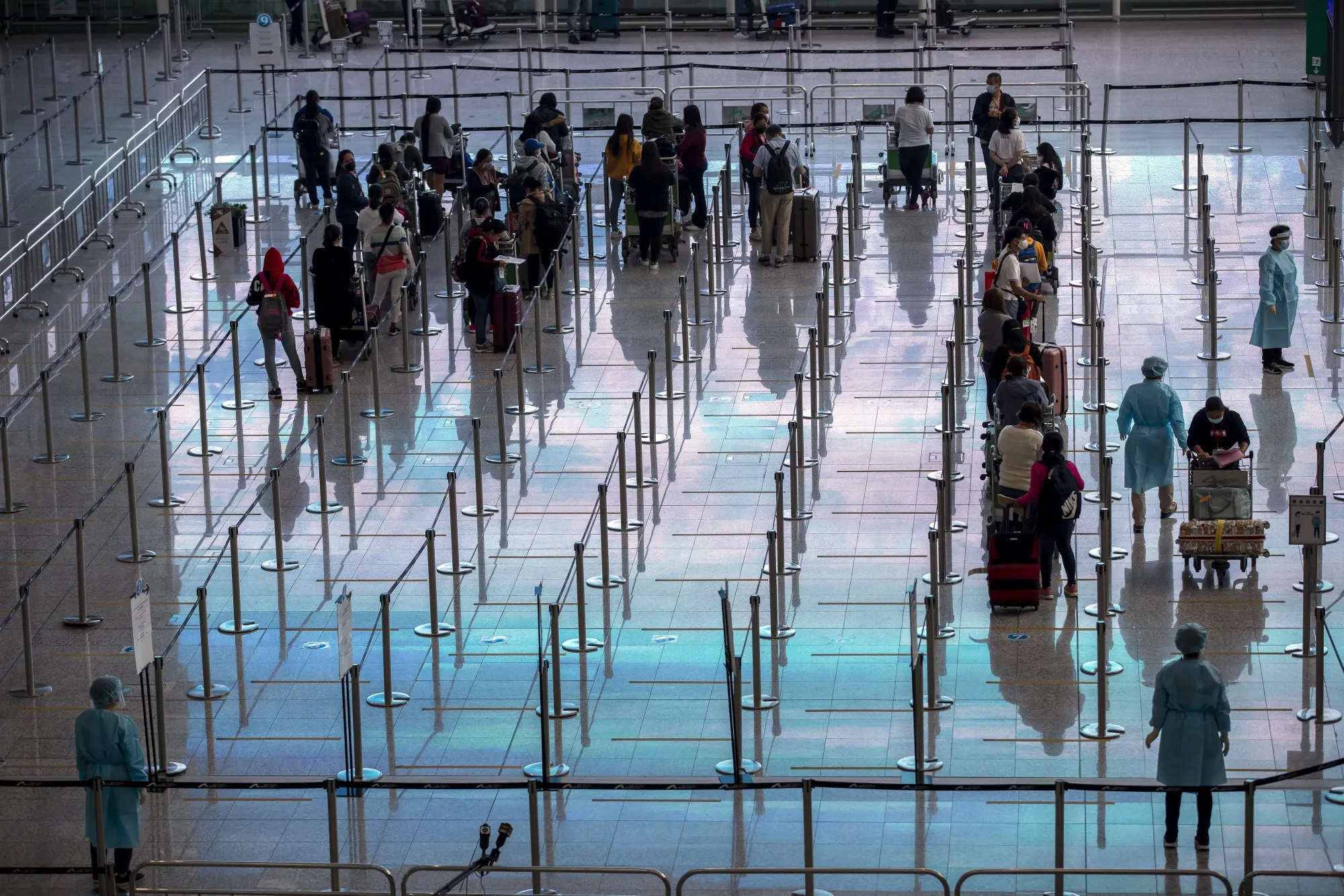Travelers heading to quarantine in the arrival hall at Hong Kong International Airport.