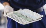 A healthcare worker holds a tray of syringes at a Covid-19 vaccination center in Munich.