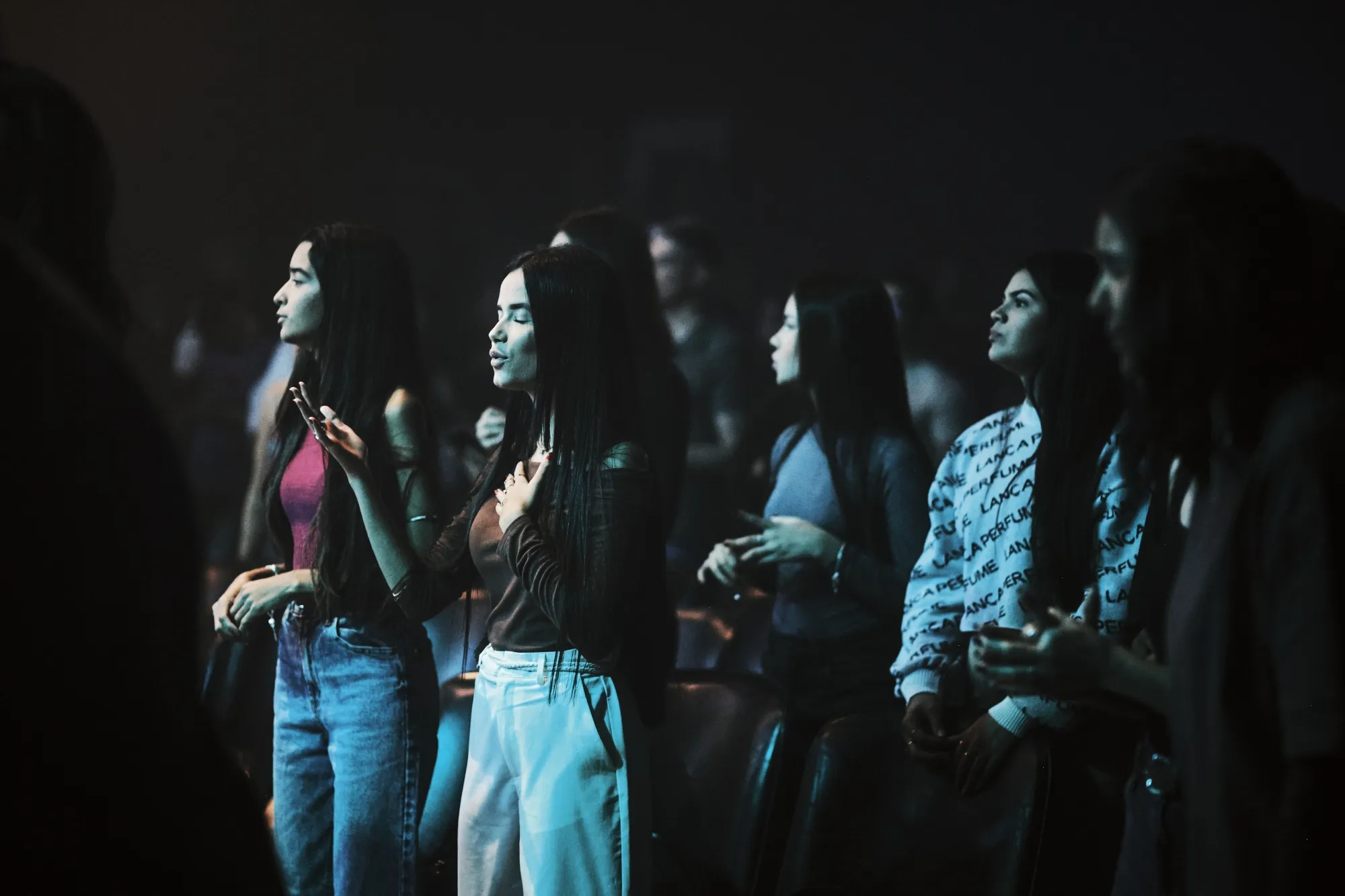 Jovens ouvem uma banda de gospel pop-rock tocar durante um culto jovem na Igreja Casa em Goiânia.