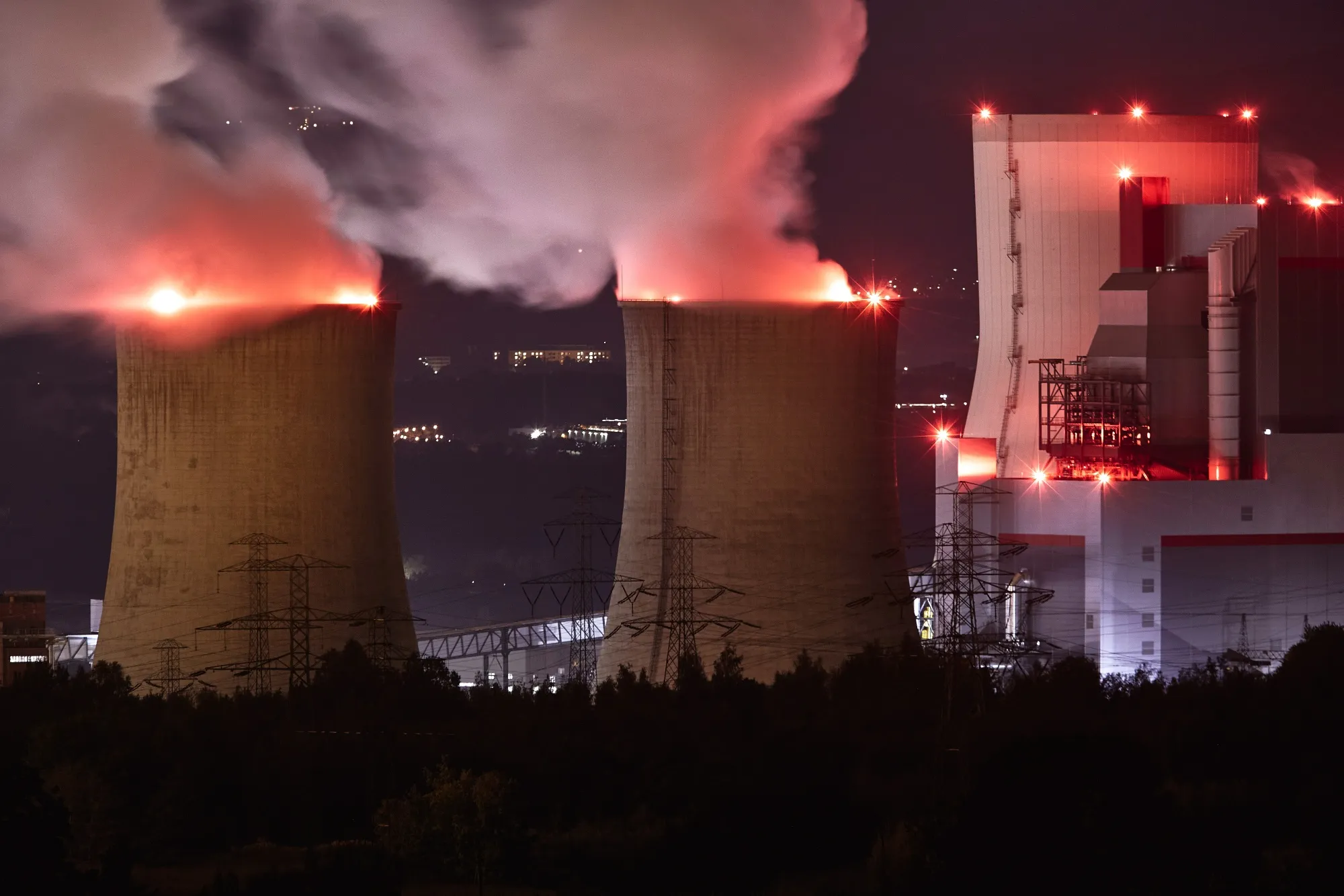 Emissions rise from chimneys at the Turow coal powered power plant, operated by PGE SA, at night in Bogatynia, Poland, on Tuesday, Sept. 29, 2020. Poland may finally be on the path to set the end-date for its unprofitable coal industry as an agreement with mining unions is within sight.