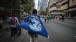 A demonstrator wears a flag as a cape during the People's Climate March in New York, U.S., on Sunday, Sept. 21, 2014.

