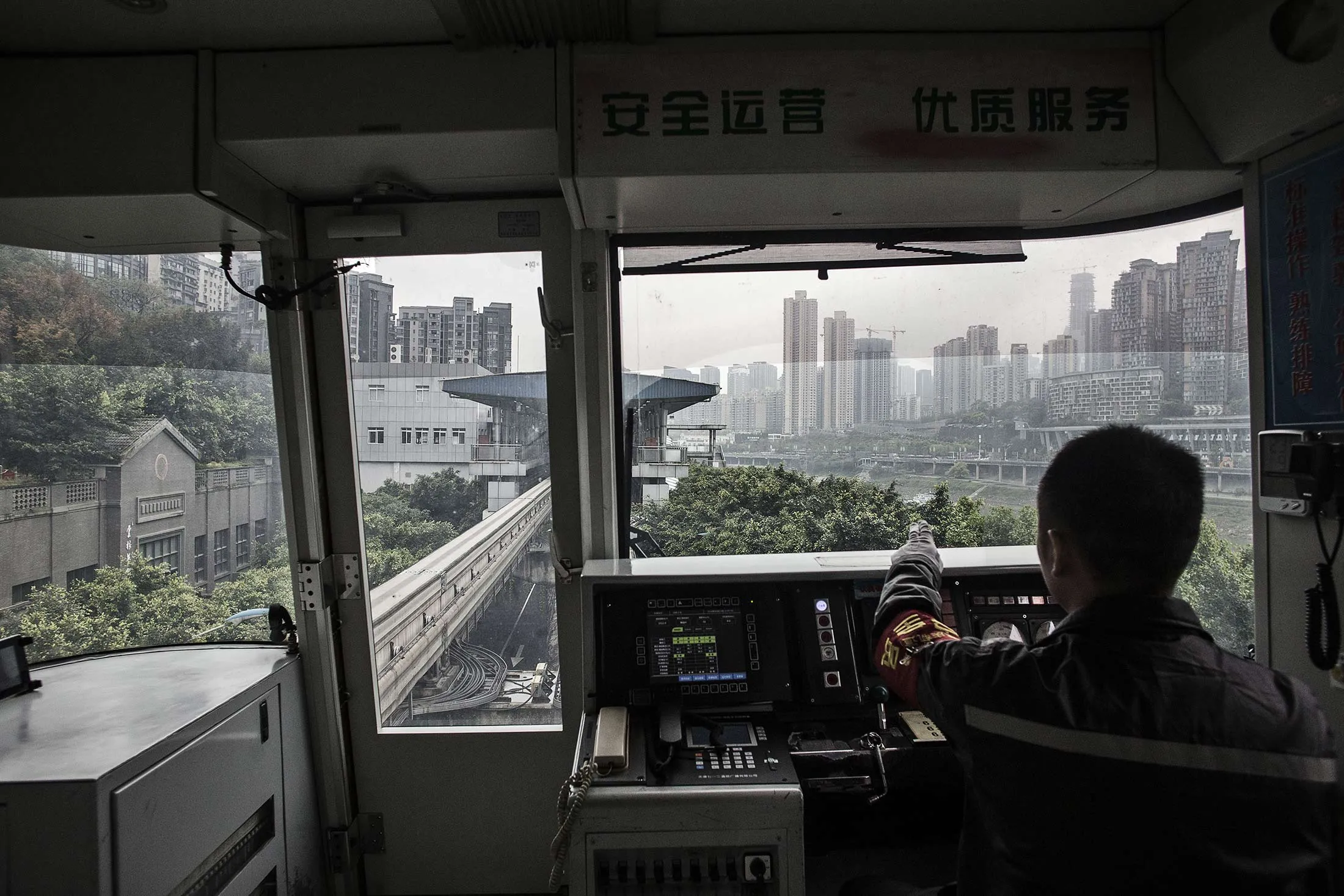 An employee operates a Chongqing Rail Transit Group Co. (CRT) train as it arrives at a station in Chongqing, China, on Tuesday, April 12, 2016.
