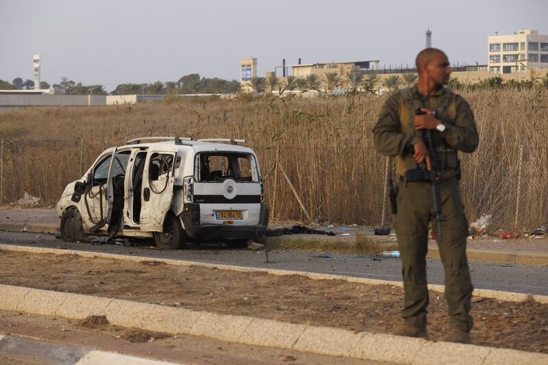 An Israeli soldier beside a vehicle hit by a rocket fired by Hamas militants in Netivot, Israel, on Sunday, Oct. 22, 2023.