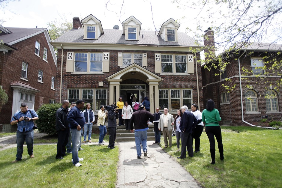 People enter and exit a home being auctioned in the Boston Edison neighborhood of Detroit, Michigan May 17, 2014. The city of Detroit and the Detroit Land Bank are auctioning off homes throughout the city to try and aid communities with abandoned homes.
