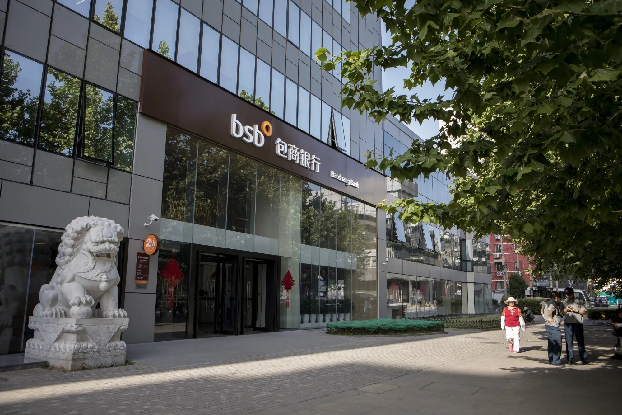 A pedestrian passes in front of a Baoshang Bank branch in Beijing.