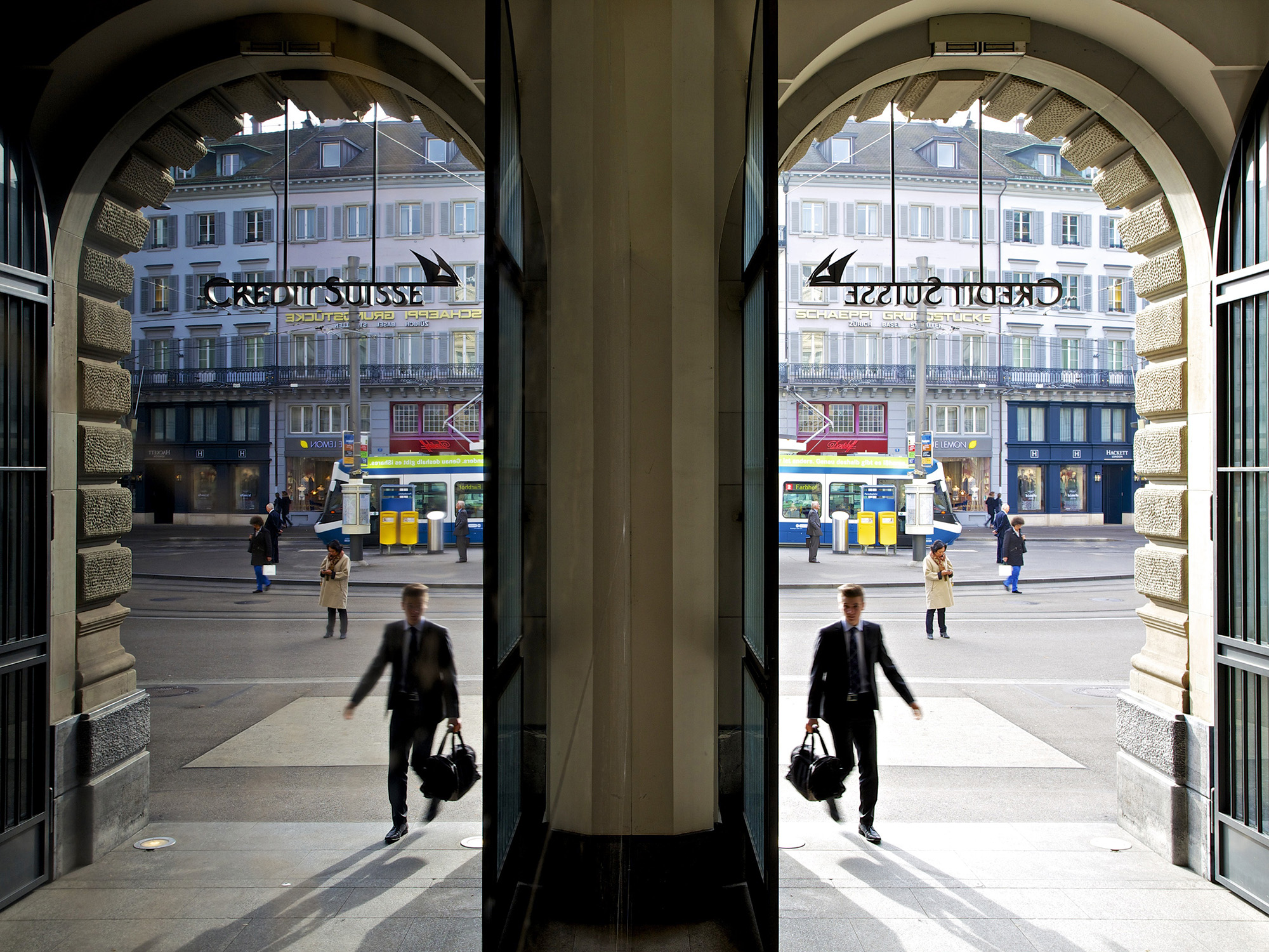 A visitor is reflected in a window as he enters a Credit Suisse Group AG office in Zurich, Switzerland.