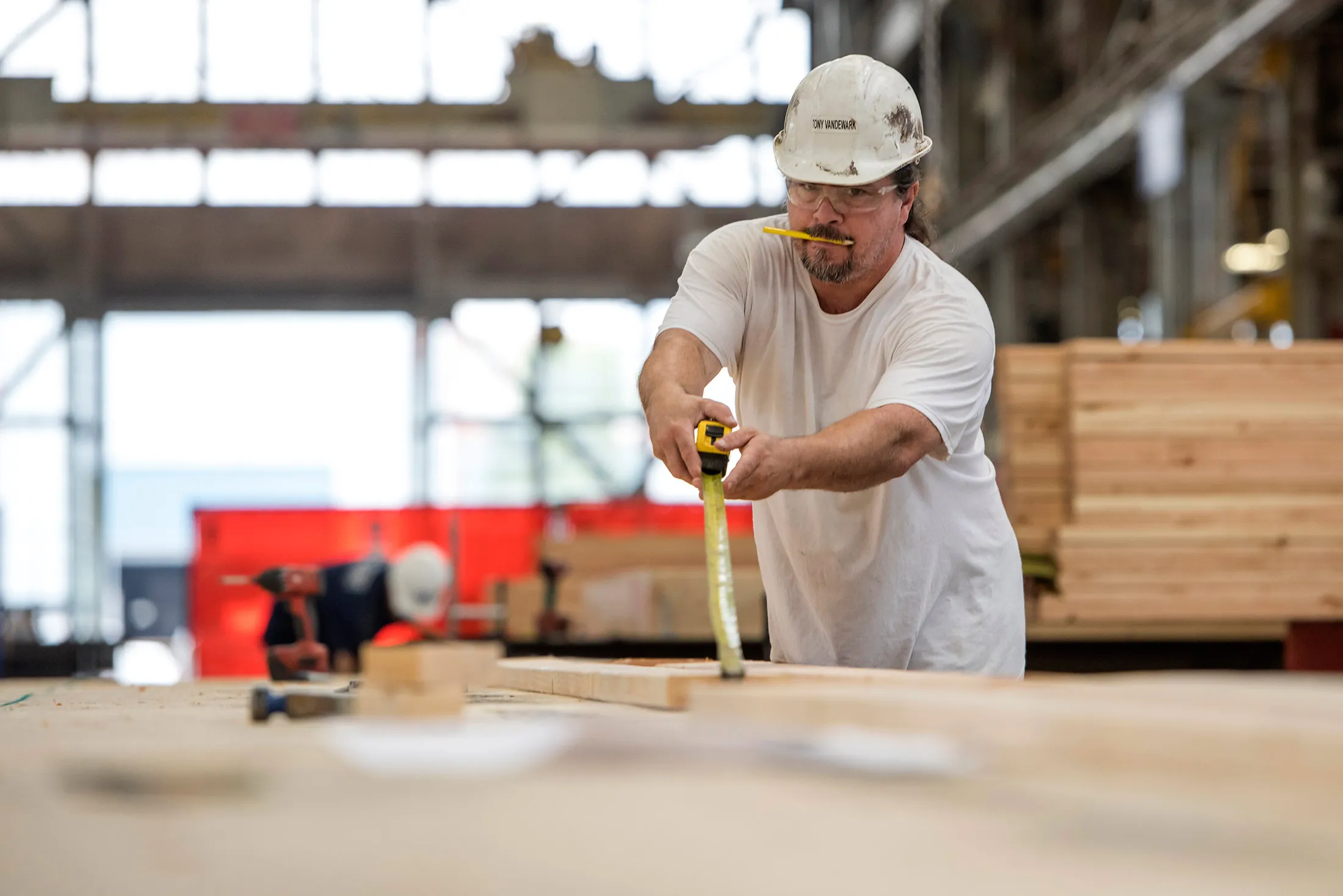 A worker uses a tape measure while assembling a floor at a modular home production facility in Vallejo, Calif. on Sept. 11.
