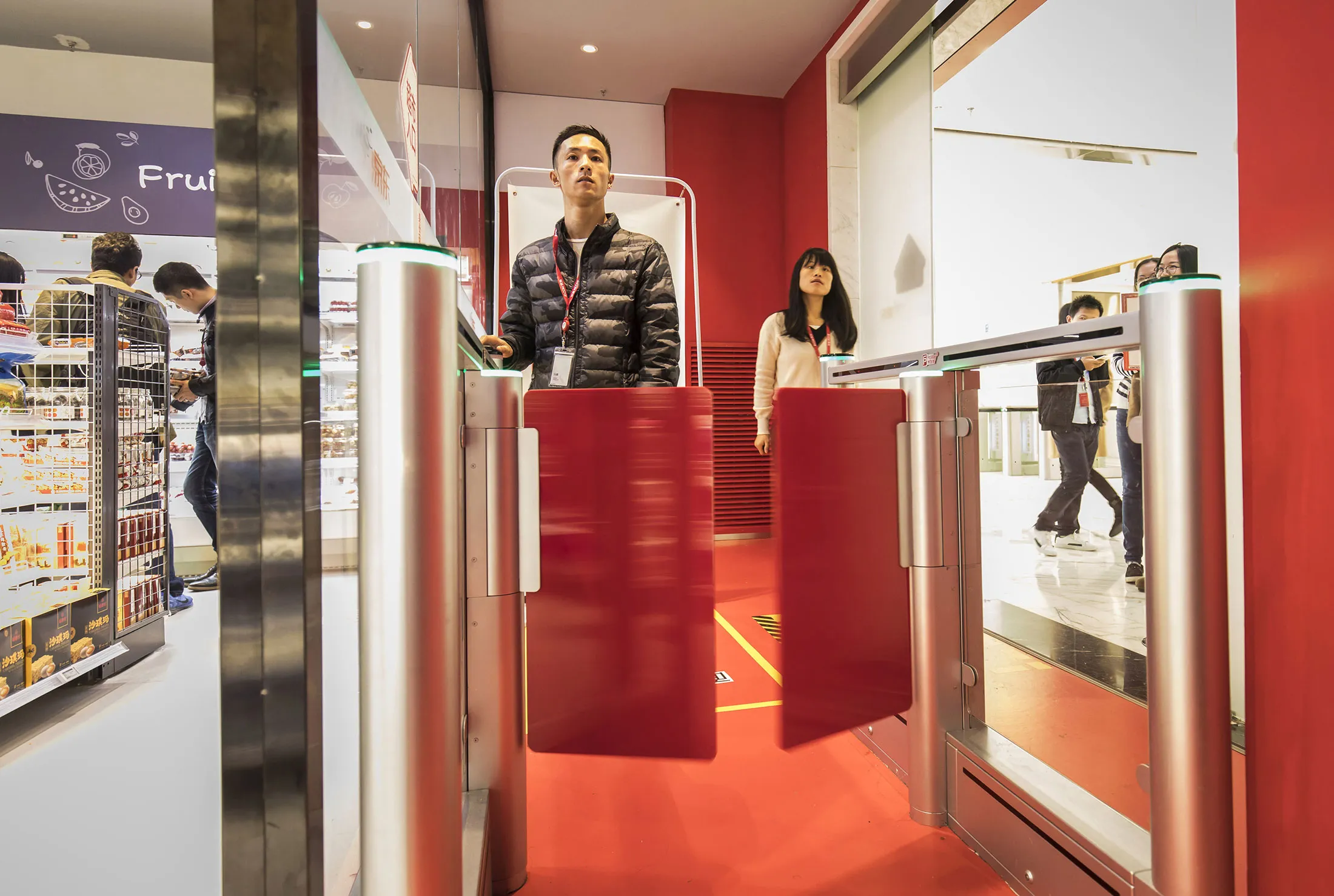 A customer stands for a facial recognition device while scanning his smartphone at an entrance to a JD.com Inc. Unmanned Convenience Store inside the company's headquarters in Beijing.