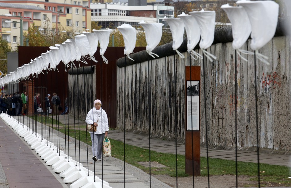 A woman walks in front of stands for balloons placed along the Berlin Wall memorial site in Bernauer Strasse, which will be used in the anniversary installation 'Lichtgrenze' (Border of Light) in Berlin November 6, 2014.