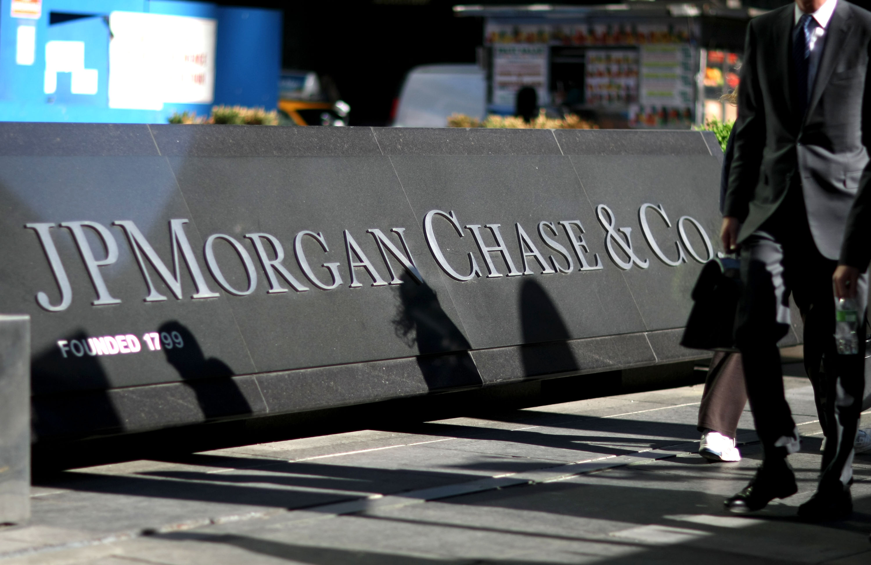 Pedestrians walk past the JPMorgan Chase &amp; Co. headquarters in New York.