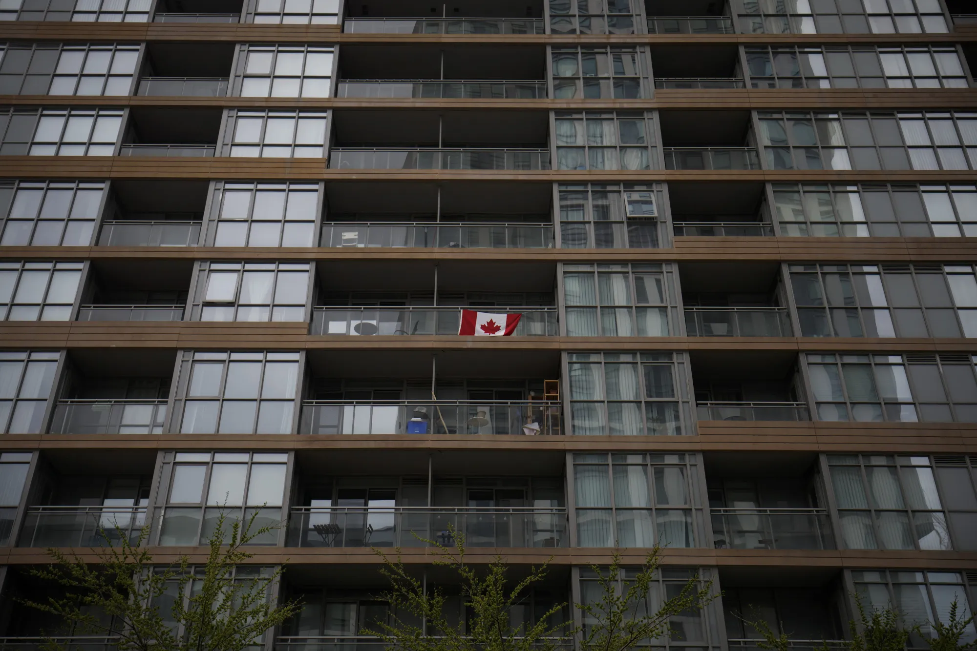 A Canadian flag flies from the balcony of a condominium unit in Toronto.