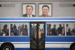 Commuters ride a bus past the portraits of late North Korean leaders Kim Il Sung and Kim Jong Il, on Kim Il Sung square in Pyongyang.