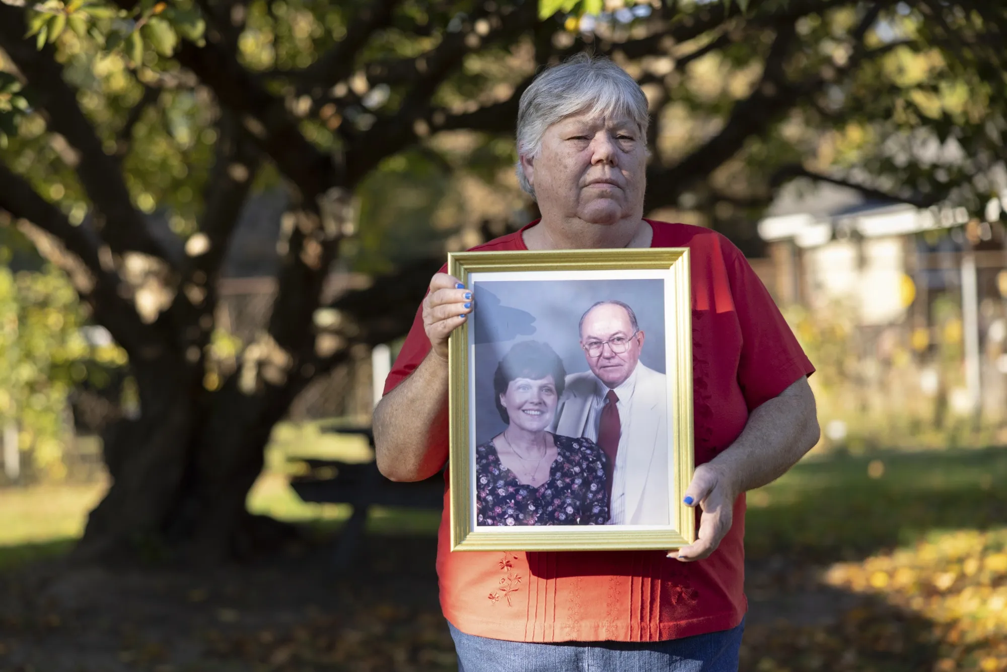 Debbie Clendenin holds a portrait of her father, Calvin Koch