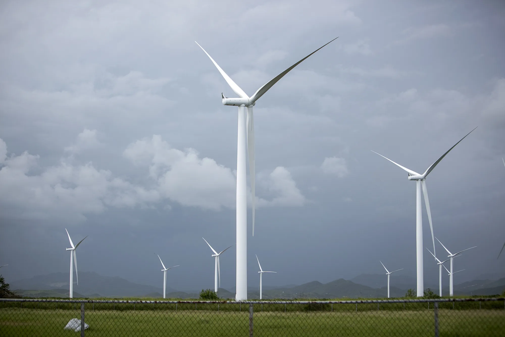 Wind turbines stand in Barrio Jauca, Santa Isabel, Puerto Rico, on Monday, Oct. 23, 2017. For longer than most can remember, Puerto Ricans have paid some of the highest energy costs in the U.S. to a notoriously unreliable utility that neglected their grid for years and runs fossil-fuel plants that may be damaging their lungs. A month after Hurricane Maria devastated the island, power lines still lay slack along roads, utility poles are snapped clean in half, and most Puerto Ricans remain in the dark.