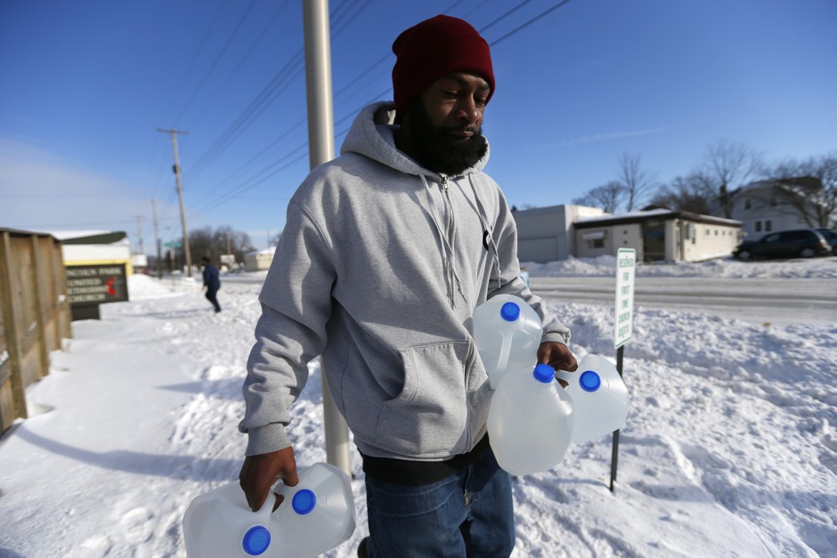 Lemott Thomas carries free water being distributed at the Lincoln Park United Methodist Church in Flint, Michigan. 