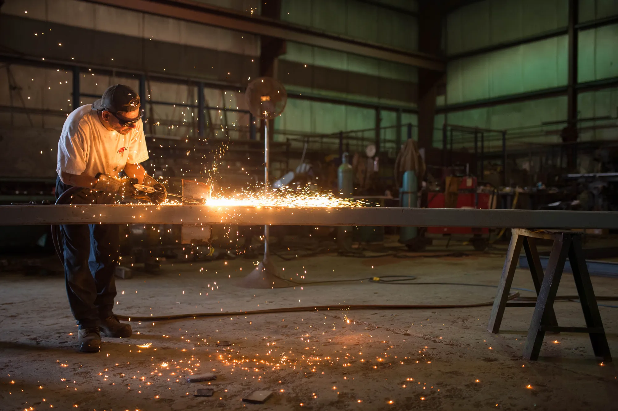 A metal worker preps steel for the base framework of a modular farming unit at a manufacturing facility in Cornwall, Ontario.