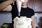 Chelsey White adds a layer of pink buttercream frosting to a cake at her apartment.