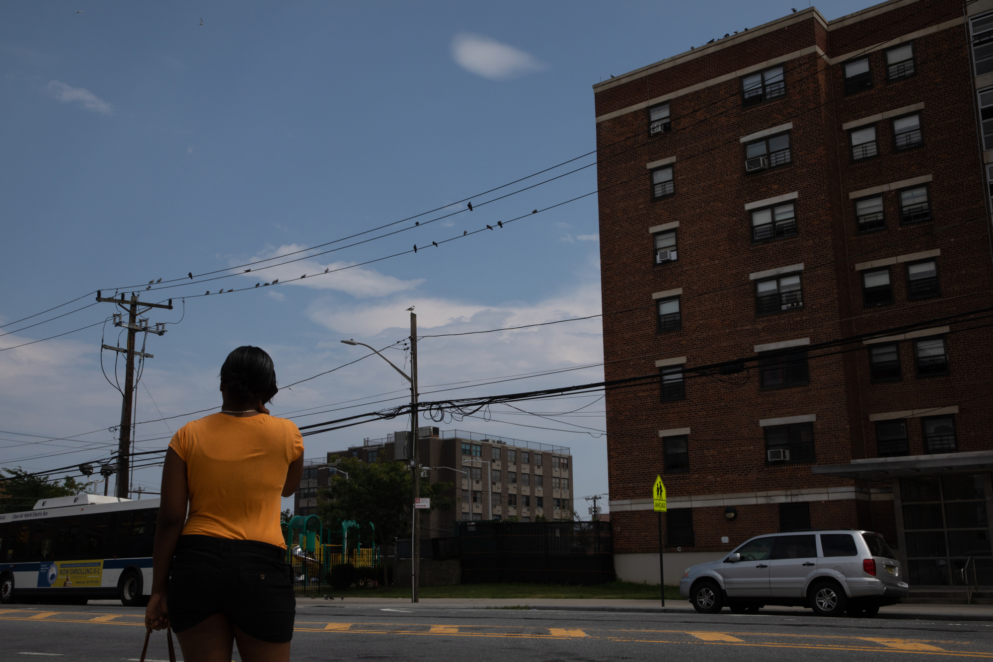 A pedestrian stands in front of the New York City Housing Authority’s Ocean Bay Apartments complex in&nbsp;2018.&nbsp;