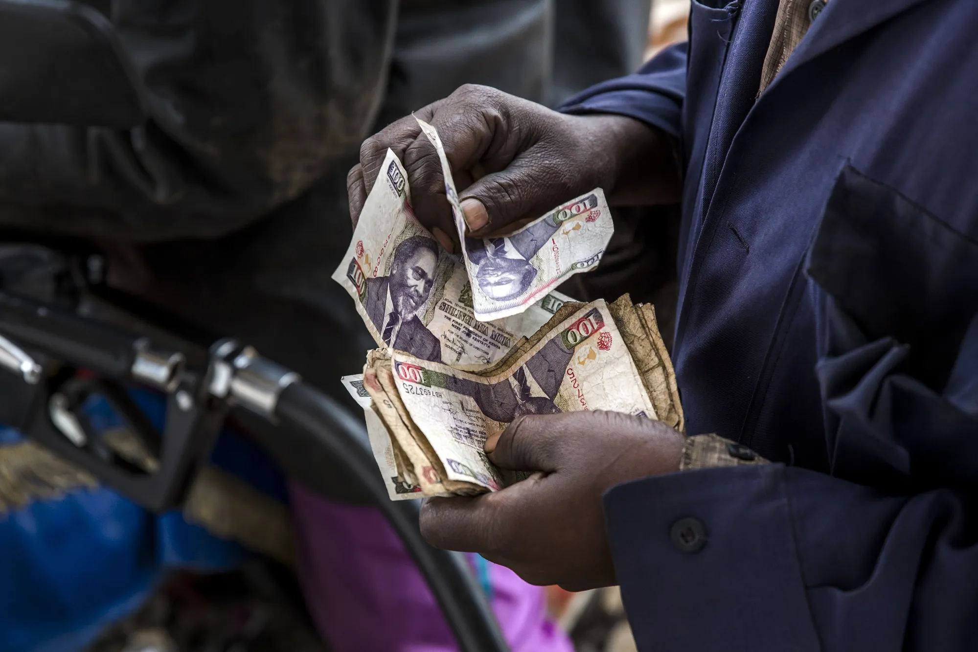 A person counts Kenyan shilling banknotes.&nbsp;