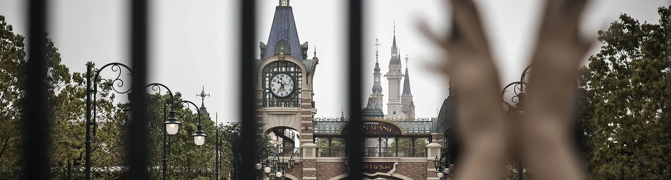 A child holds onto a gate at the Walt Disney Co.'s Disneyland Resort in Shanghai, China, on Saturday, May 7, 2016. Disney employees and partners will get a sneak peek of the $5.5 billion Shanghai Disneyland from this weekend, as the world's largest entertainment company gets set for next month's official opening of its first theme park in mainland China.
