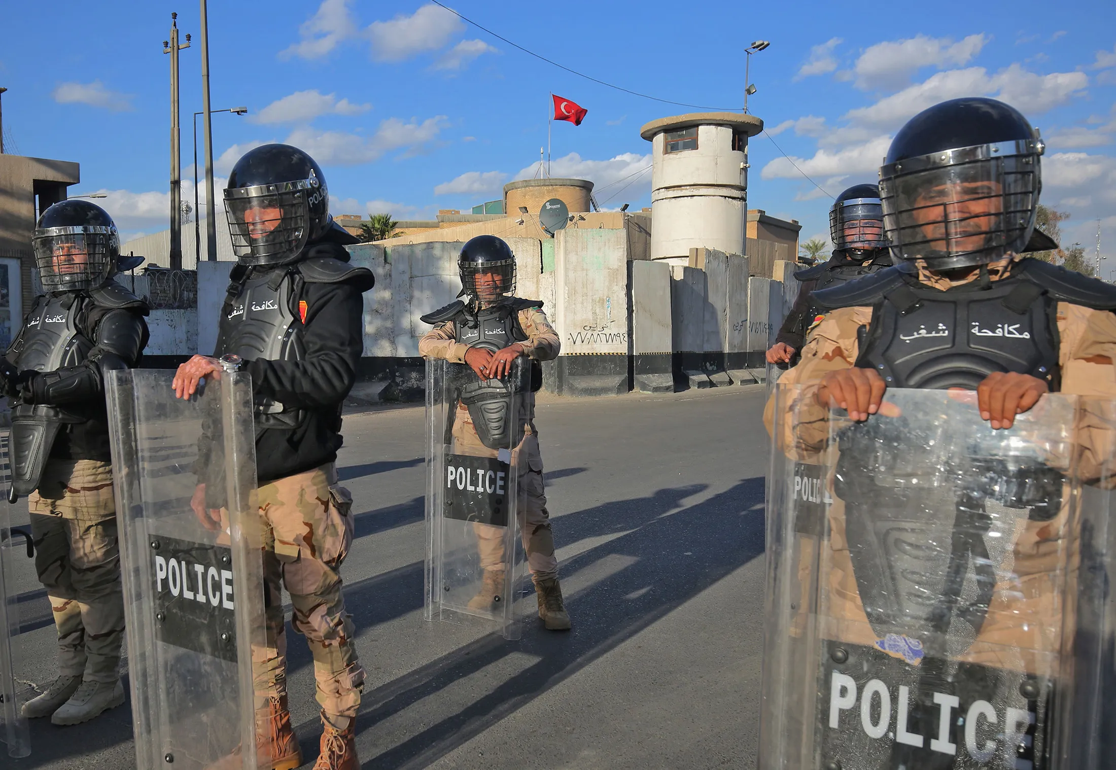 Iraqi riot police protect the Turkish embassy in Baghdad on Feb. 18.