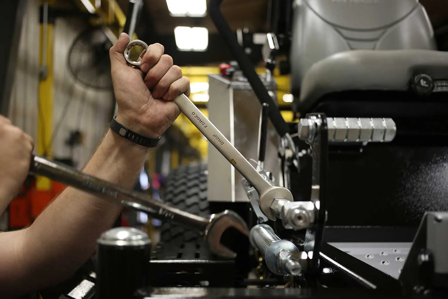 A worker tightens a bolt on a completed lawnmower at the Dixie Chopper manufacturing facility in Coatesville, Indiana, on June 12, 2015.
