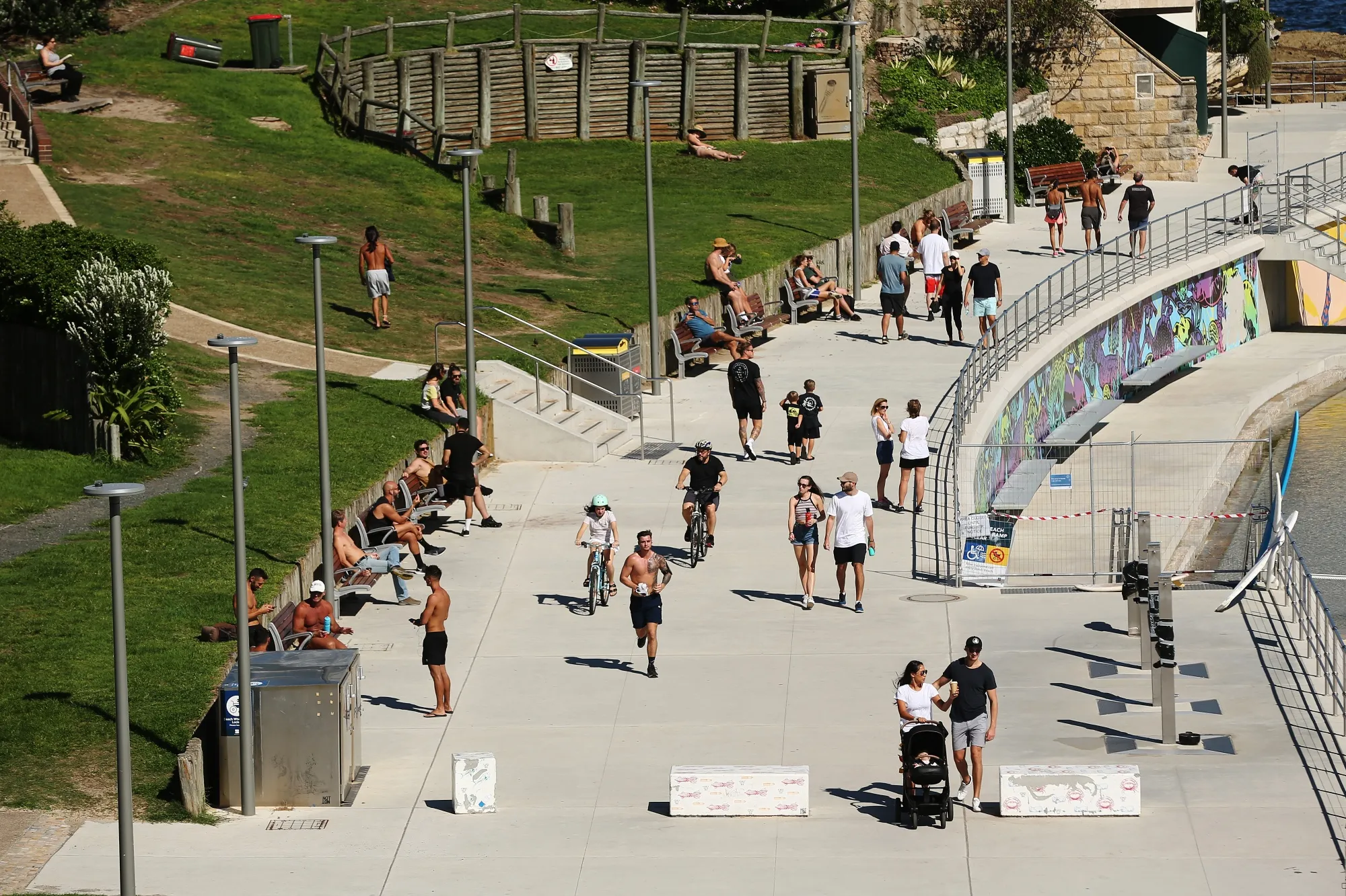 A jogger runs past people gathered during a partial lockdown imposed due to the coronavirus in Bondi Beach, Sydney on&nbsp;April 4.