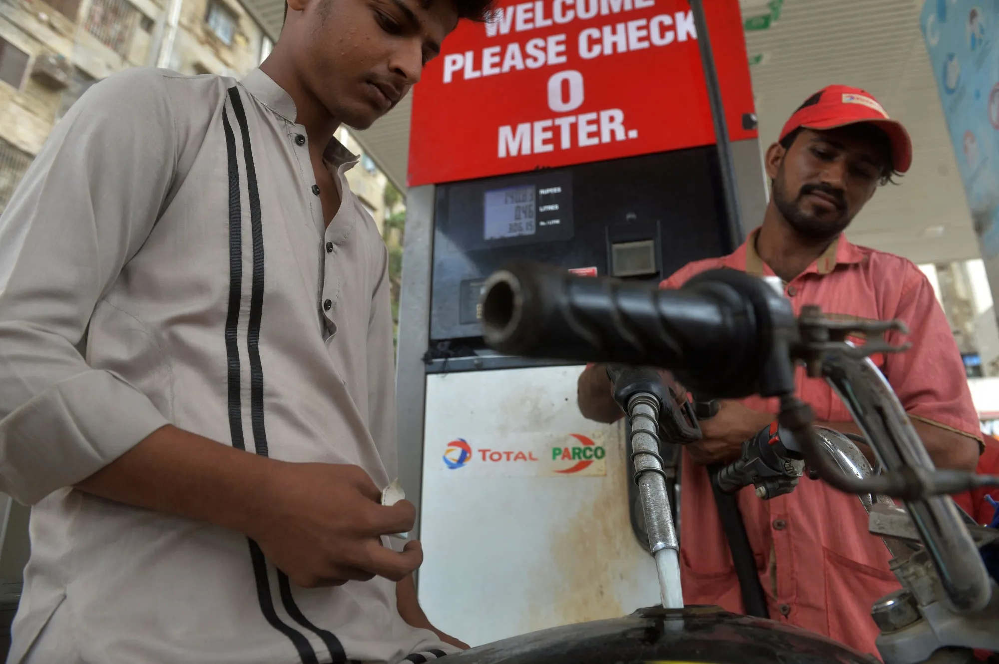 An employee refuels a motorcycle at a Total Parco gas station in Karachi.